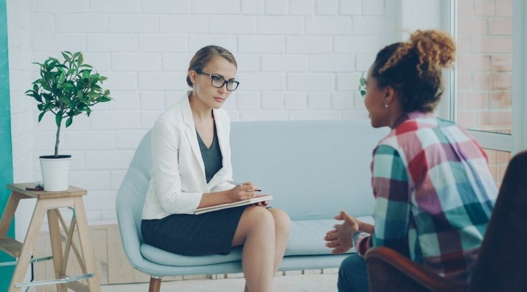 Professionnelle prenant des notes face à une personne en entretien